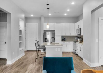 A white open-concept kitchen as seen from the living room.